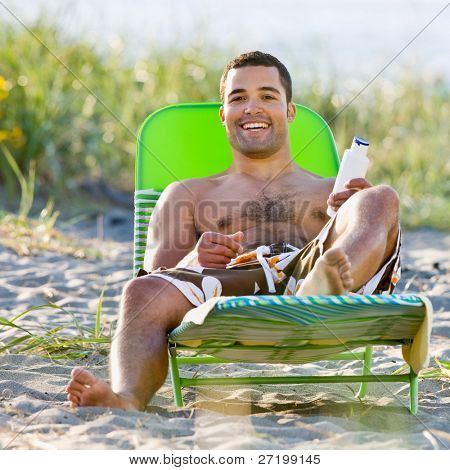 Homme, application de lotion écran solaire à la plage