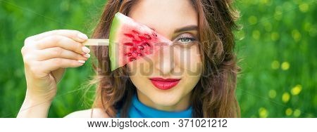 Triangle Of Watermelon On A Stick In The Hands On The Girls Eye On A Green Background. Banner For Si
