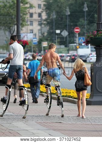 St. Petersburg, Russia, 06.2013. Young People Walking On The Street On A Jumping Stilts