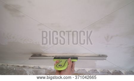 The Worker Processes The Wall With Putty. Hand With Putty Knife Repair Wall, Hand With A Spatula, Sp