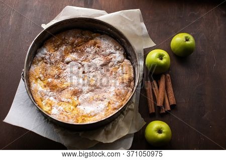 Homemade Pie, Green Apples And Cinnamon Sticks On Brown Wooden Table. Homemade Pastries