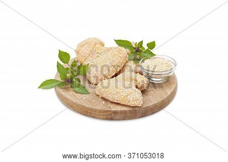 Raw Crispy Chicken Boneless Drumstick Breaded In Bread Crumbs And Sesame On A Wooden Board With Lore