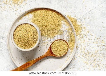 Plate Of Raw Amaranth Grain With A Spoon Top View On A White Table