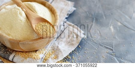 Bowl Of Raw Amaranth Flour With A Spoon Of Amaranth Seeds On A Grey Table Close Up