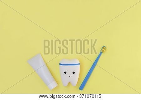 Toy Tooth, Toothbrush And Toothpaste On Bright Yellow Background. Signboard For Stomatology, Dentist