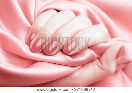 Female Hand With Pale Pink Manicure On A Pink