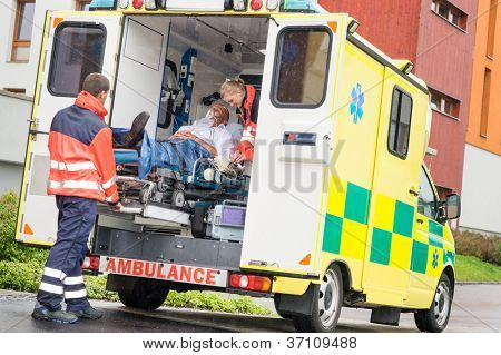 Uvedení pacienta záchranáři muže kyslíkovou masku v sanitkou