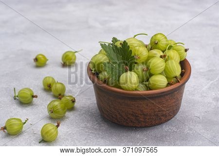 Gooseberries In A Ceramic Bowl Close-up On A Light Background.