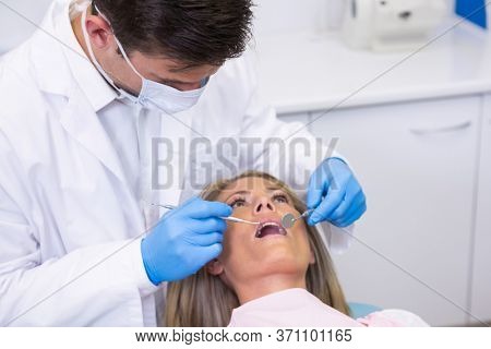 Close up of dentist examining woman at dental clinic