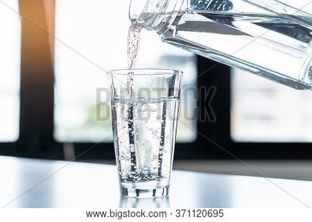 Person Pouring Down Mineral Water To Glass.