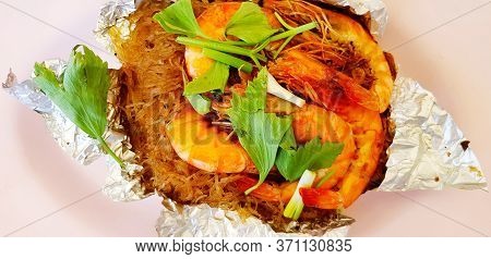 Close Up Sweet Casseroled Prawns With Vermicelli, Tang Dong On Shredded Paper In Pink Dish Or Plate.
