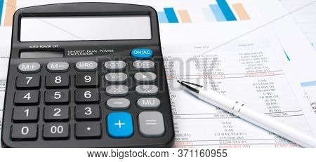 Calculator On Financial Papers At The Table Close Up