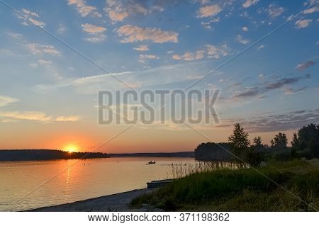 colorful sunset and people swimming in the lake