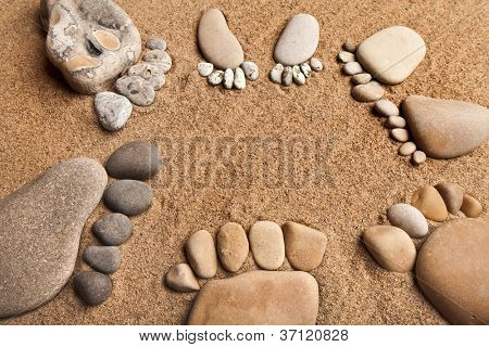 Trace fødder af en sten sten på sea sand kulisse, konceptet happy family