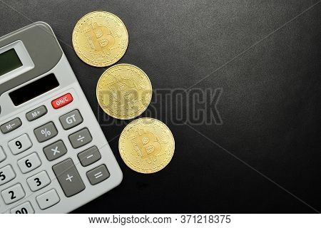 Cryptocurrency Bitcoin With Calculater On Black Background With Text Space