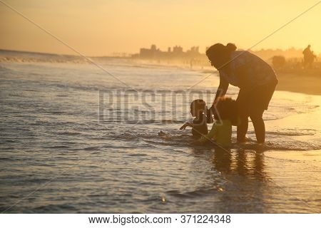 Salvador, Bahia / Brazil - February 26, 2018: Woman Is Seen Playing With Children On Pituacu Beach I