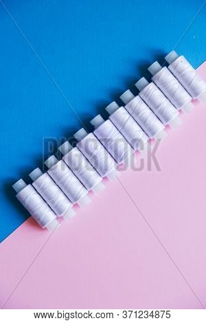 Row Of Whitethread Spools On Table Flatlay