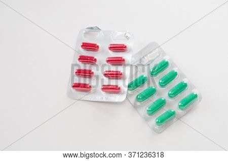 Red And Green Pills In Individual Covers