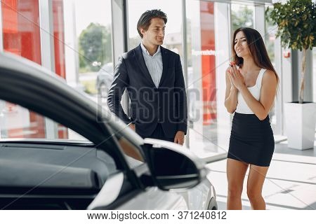 Stylish And Elegant Couple In A Car Salon