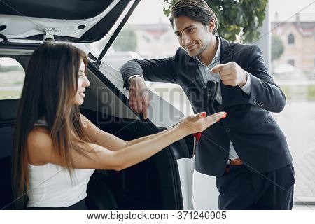 Stylish And Elegant Couple In A Car Salon