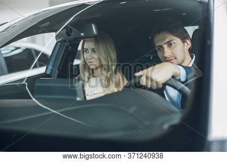 Stylish And Elegant Couple In A Car Salon