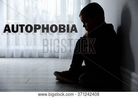 Sad Little Boy Sitting Alone Near Light Wall At Home. Autophobia