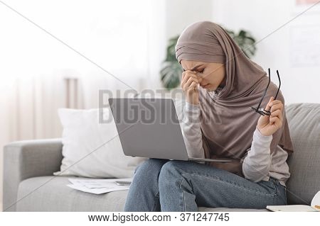 Tired Eyes. Exhausted Arabic Woman In Headscarf Having Eyesight Problem While Working On Laptop At H
