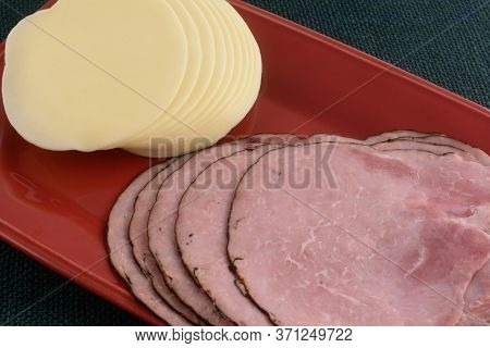 Stacks Of Black Forest Ham And Provolone Cheese Scold Cut Slices On Red Platter