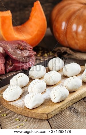 Traditional Russian Dish Of Manti Dumplings With Meat And Pumpkin. On A Wooden Country Background. V