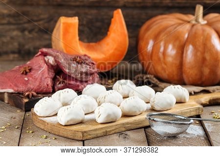 Traditional Russian Dish Of Manti Dumplings With Meat And Pumpkin. On A Wooden Country Background. H