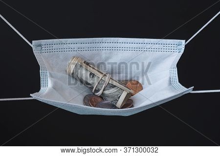 Medical Face Mask And Money On A Black Background. World Coronavirus Epidemic And Economic Losses Co