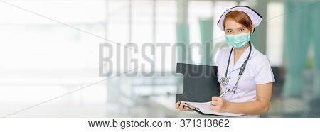 Asian Female Nurse Writing Medical Report On Ward Bed Hospital Blurred Background For Wide Banner Ba