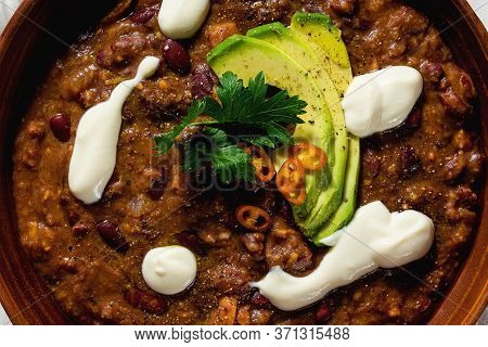 Vegan Chili Soup Without Meat, With Pinto Beans And Avocado, Served With Yogurt Made From Soy On Lin