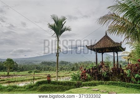 Gazebo With Table And Chairs By The Rice Fields With View On Agung Volkano On A Cloudy Day In Bali, 
