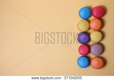 Macaroons Of Differrent Colours In A Line Isolated On Yellow Background Flat Lay. Image Contains Cop