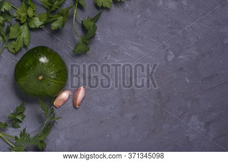 An Argentinian Pumpkin With Parsley And Garlic On A Grey Table