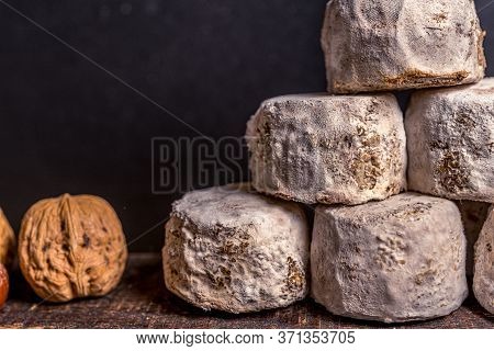 French Cheese Crottin De Chavignol With Hazelnut In The Dark Background. High Quality Photo