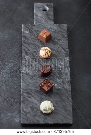 Luxury Chocolate Candies Selection On Black Marbel Board. White, Dark And Milk Chocolate Assortment.