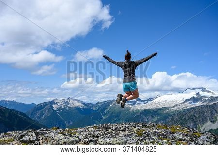 Woman Stretches Out Arms In Jump In North Cascades