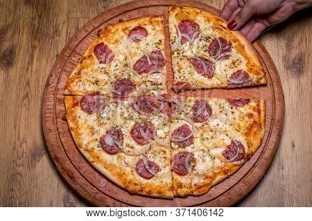 Hand Holding Pepperoni Pizza In Brazil Is Called Pizza De Calabresa. Close Up.