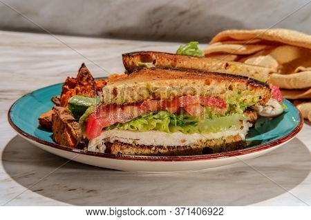 Deli Chicken Guacamole Sandwich On Gluten-free Sliced Bread With Sweet Potato Fries