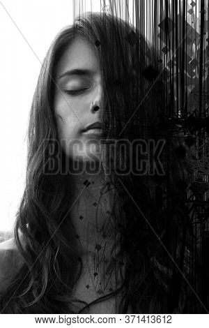 Portrait of a young pretty woman with closed eyes and long wavy hair partially covering her face