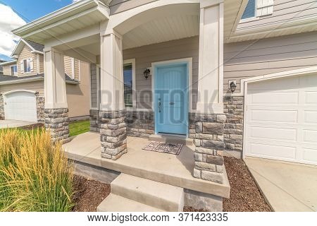 Stape And Arched Entrance At The Porch Of Home With Pastel Blue Front Door