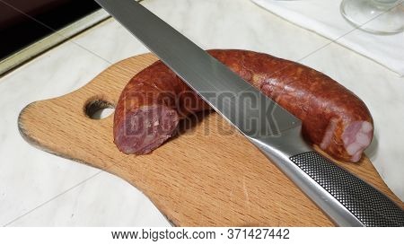 Chorizo Sausage Is Sliced On A Wooden Chopping Board