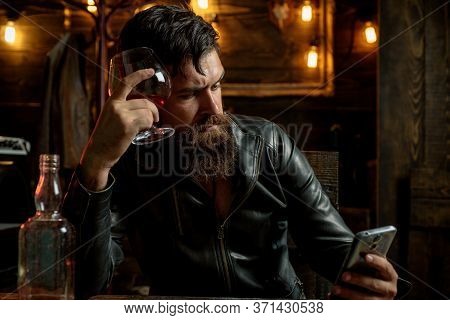 Brutal Hipster Man Drinking Alcohol. Stylish Handsome Bearded Man Enjoying Whiskey And Doing His Bus