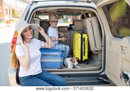 European Single-parent Family And Jack Russell Puppy Travel By Car. Toddler With His Mother And A Sm