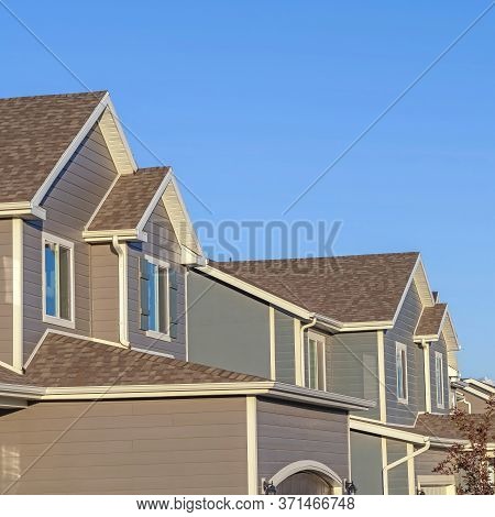 Square Row Of Houses In A Suburb Neighborhood With Mountain And Blue Sky Background