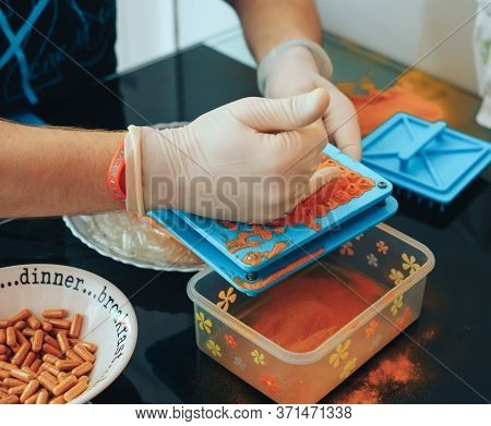 Mans Hands In Gloves Making Home Made Pills And Vitamins With Organic Turmeric Powder Using Special 