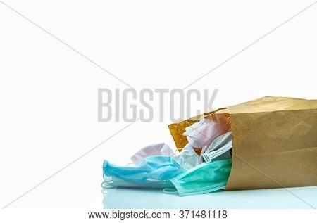 Used Surgical Face Mask In Brown Paper Bag Isolated On White Background. Medical Waste. Infectious W