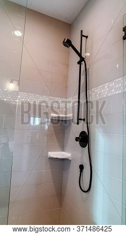 Vertical Frame Black Round Shower Head On Tile Wall Of Shower Stall With Hinged Glass Door